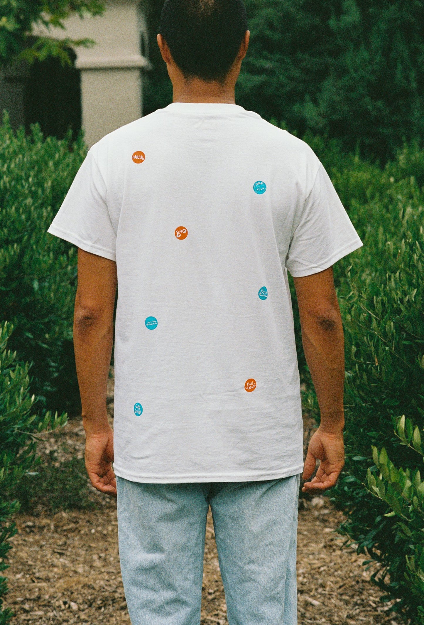 A person wearing a white tee shirt with printed take out stickers all over it