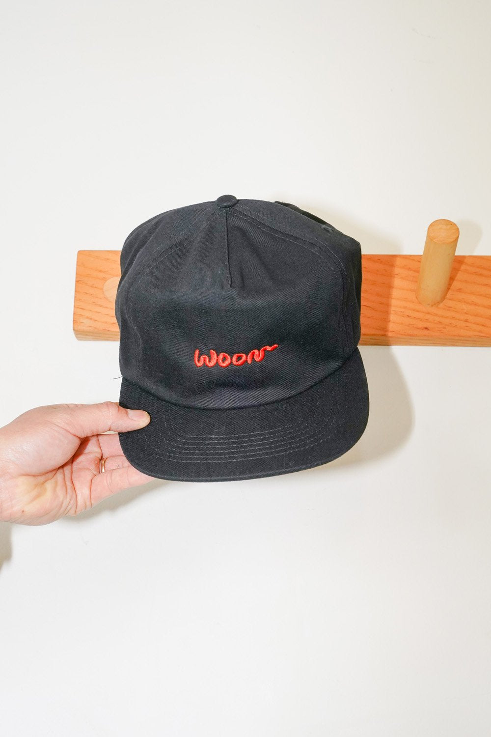 A black cap with the word Woon in orange