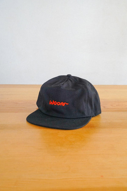 A black cap with the word Woon in orange