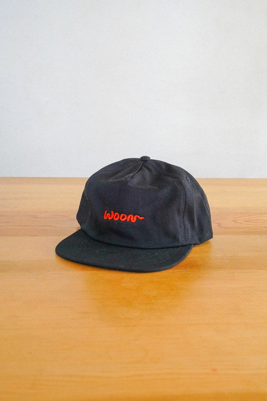 A black cap with the word Woon in orange