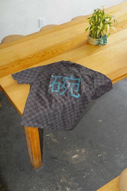 The back of an overdyed work shirt on a wooden table