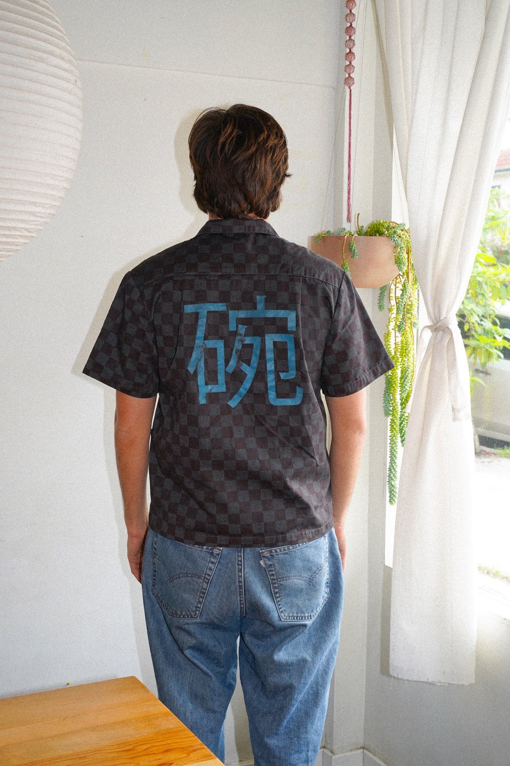 The back of a person wearing an overdyed work shirt