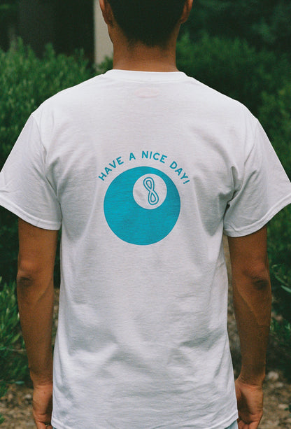 Close up of a man wearing a white t shirt with a lucky 8 ball on it