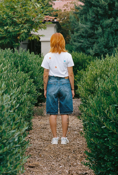 A person wearing a white tee shirt with printed take out stickers all over it